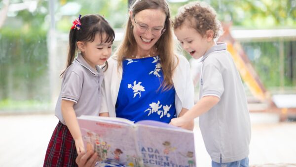 CR5_8970 A teacher reading a picture book aloud to young BASIS International School Bangkok students