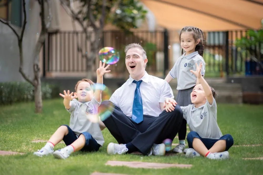 Children with their teacher playing with bubbles at BASIS International School in Bangkok