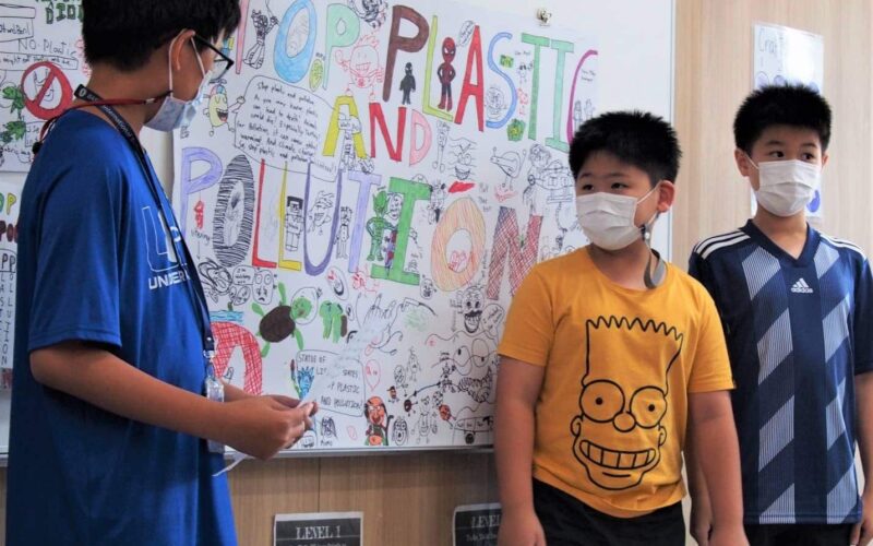 students2-min BASIS International School Bangkok students in front of a display of their artwork